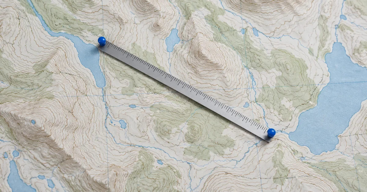 Illustration of a ruler connecting two blue markers on a contour map.